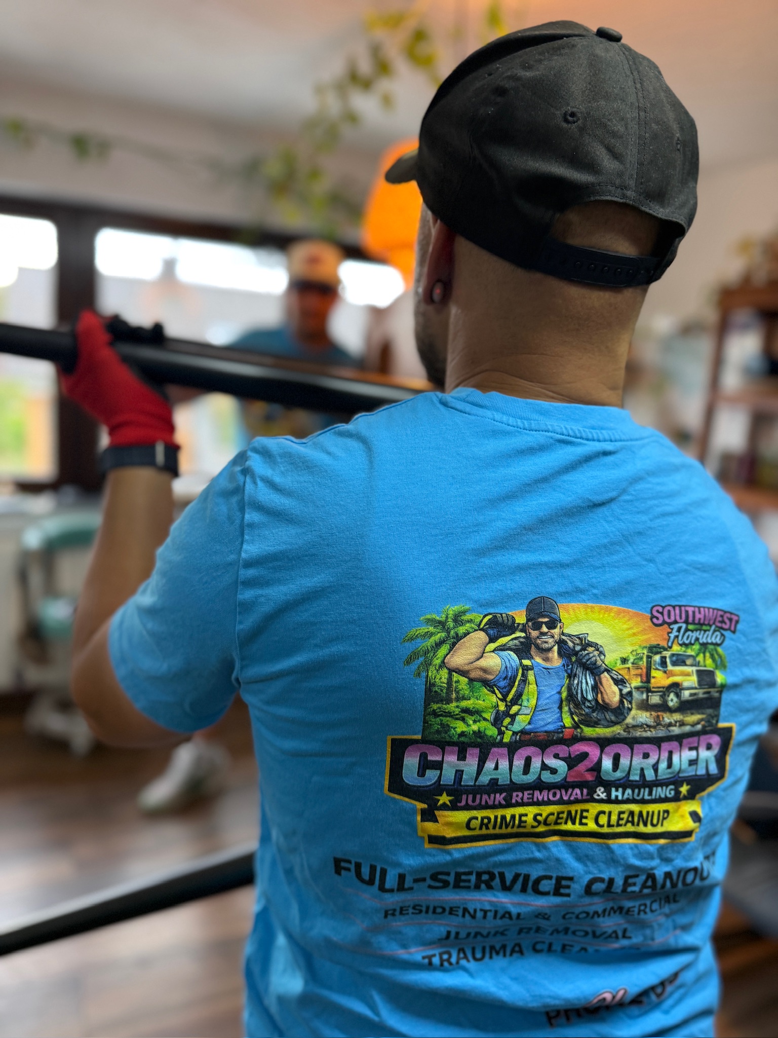 Close-up of a Chaos2Order crew member's branded shirt while carrying furniture