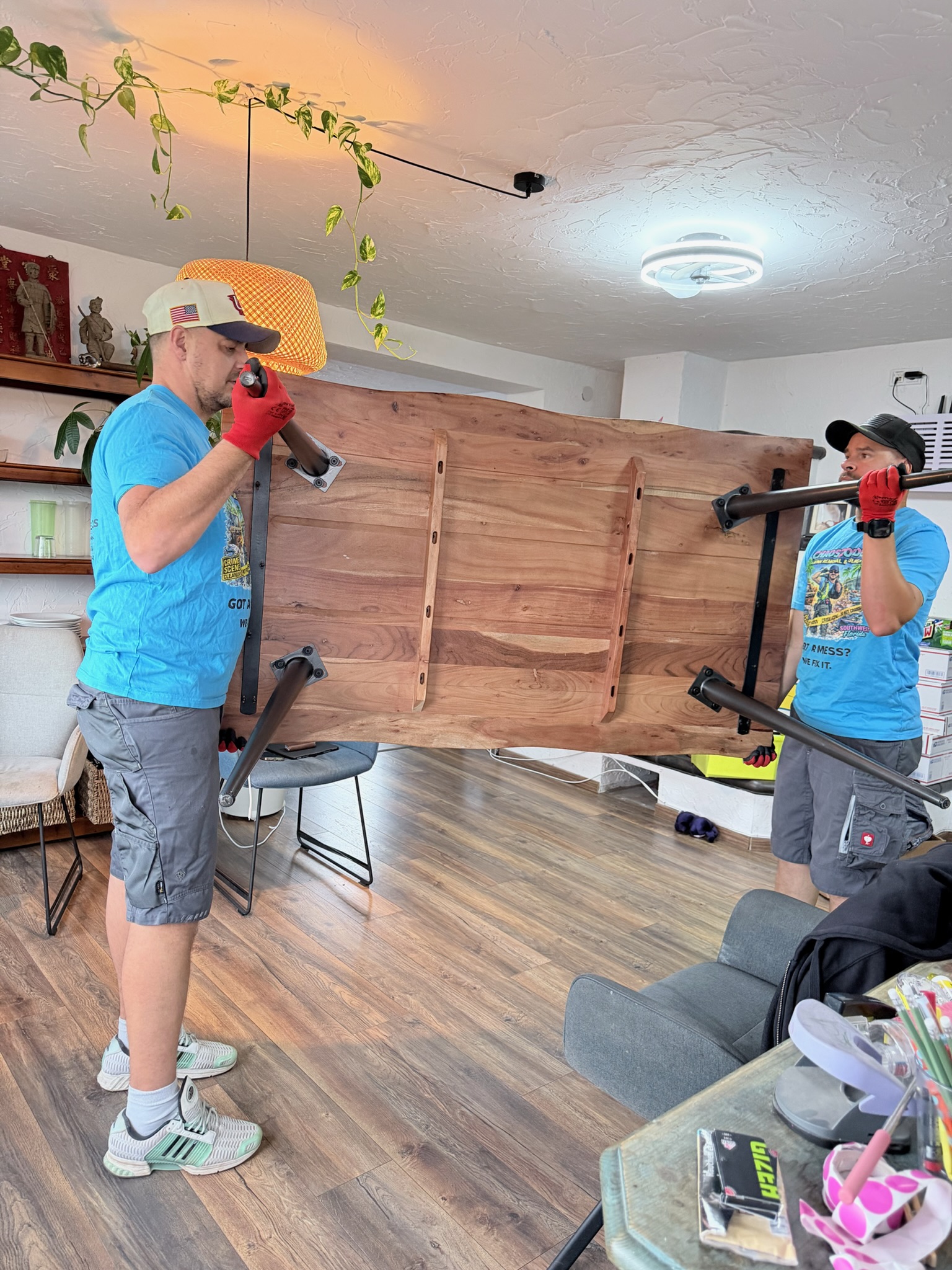 Two Chaos2Order team members carrying a wooden table inside a property