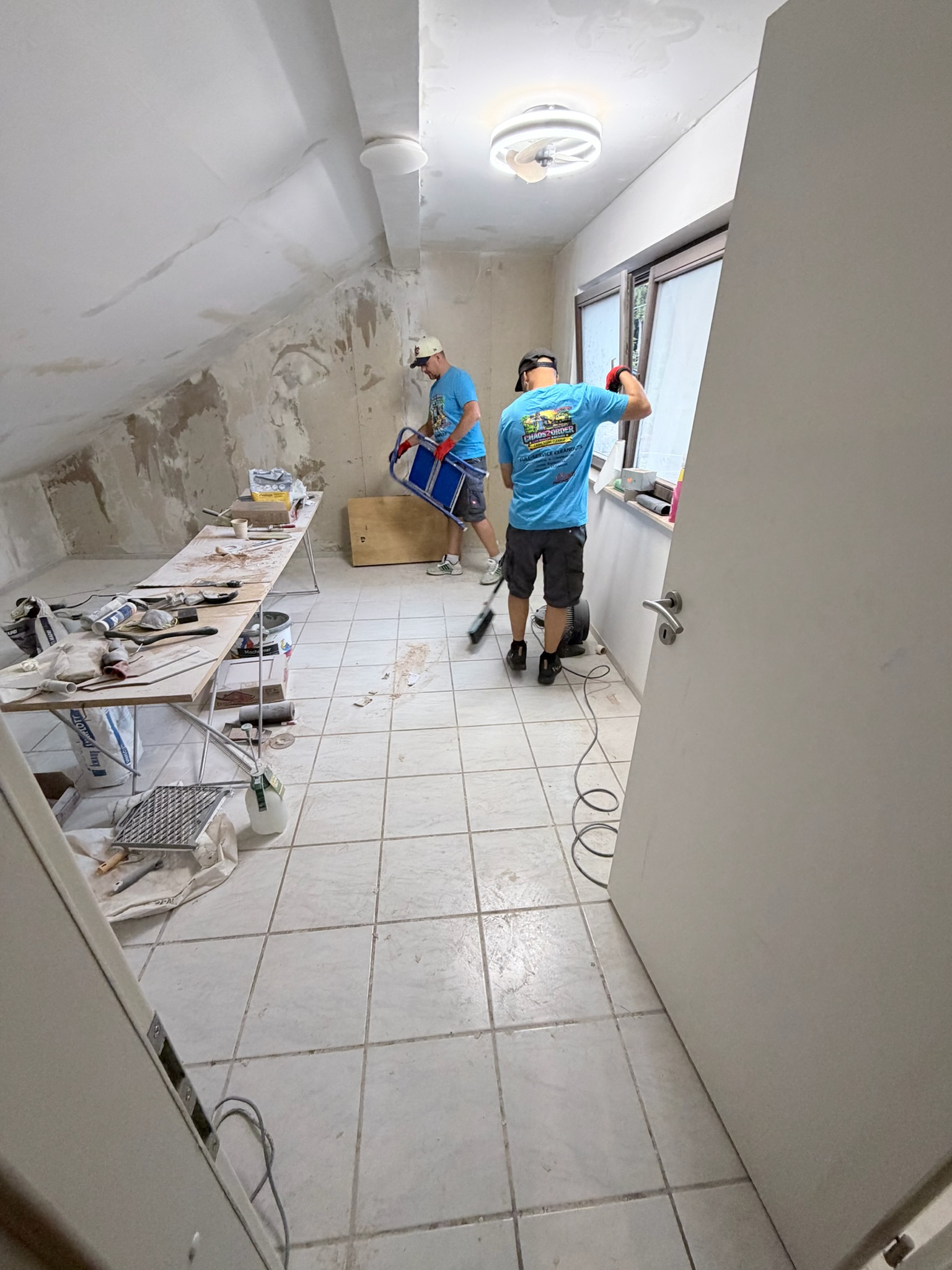 Chaos2Order crew clearing loose debris from an interior room