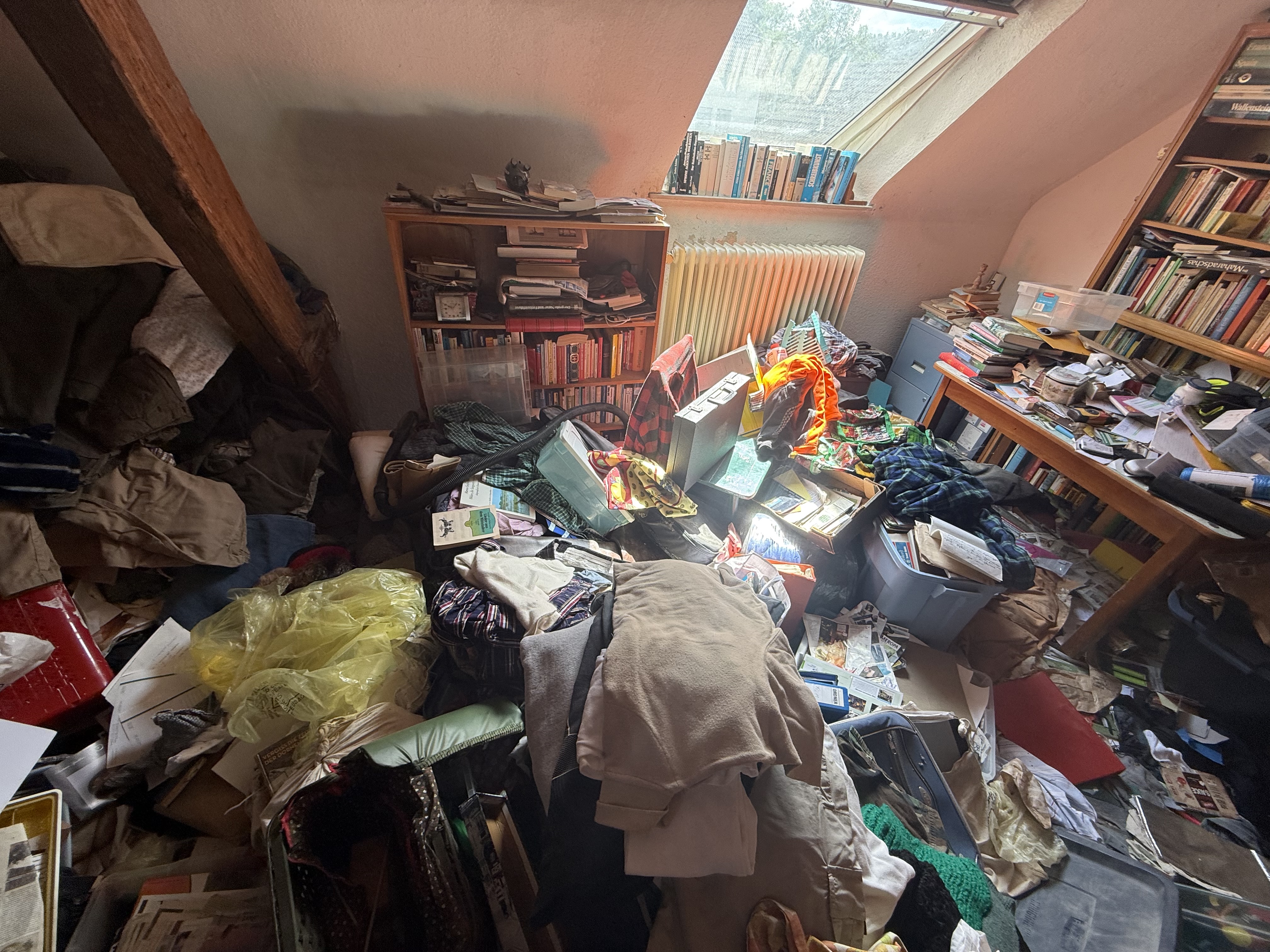 Interior room with densely accumulated bags, containers, and belongings