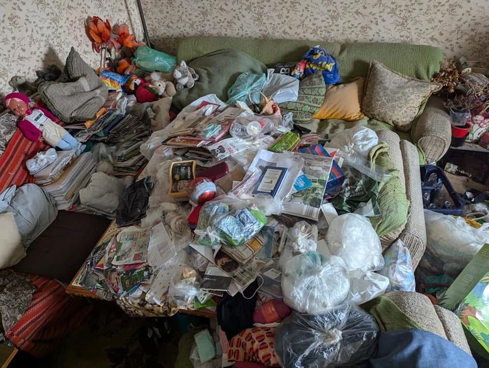 Accumulated food packaging and household waste in a cluttered room