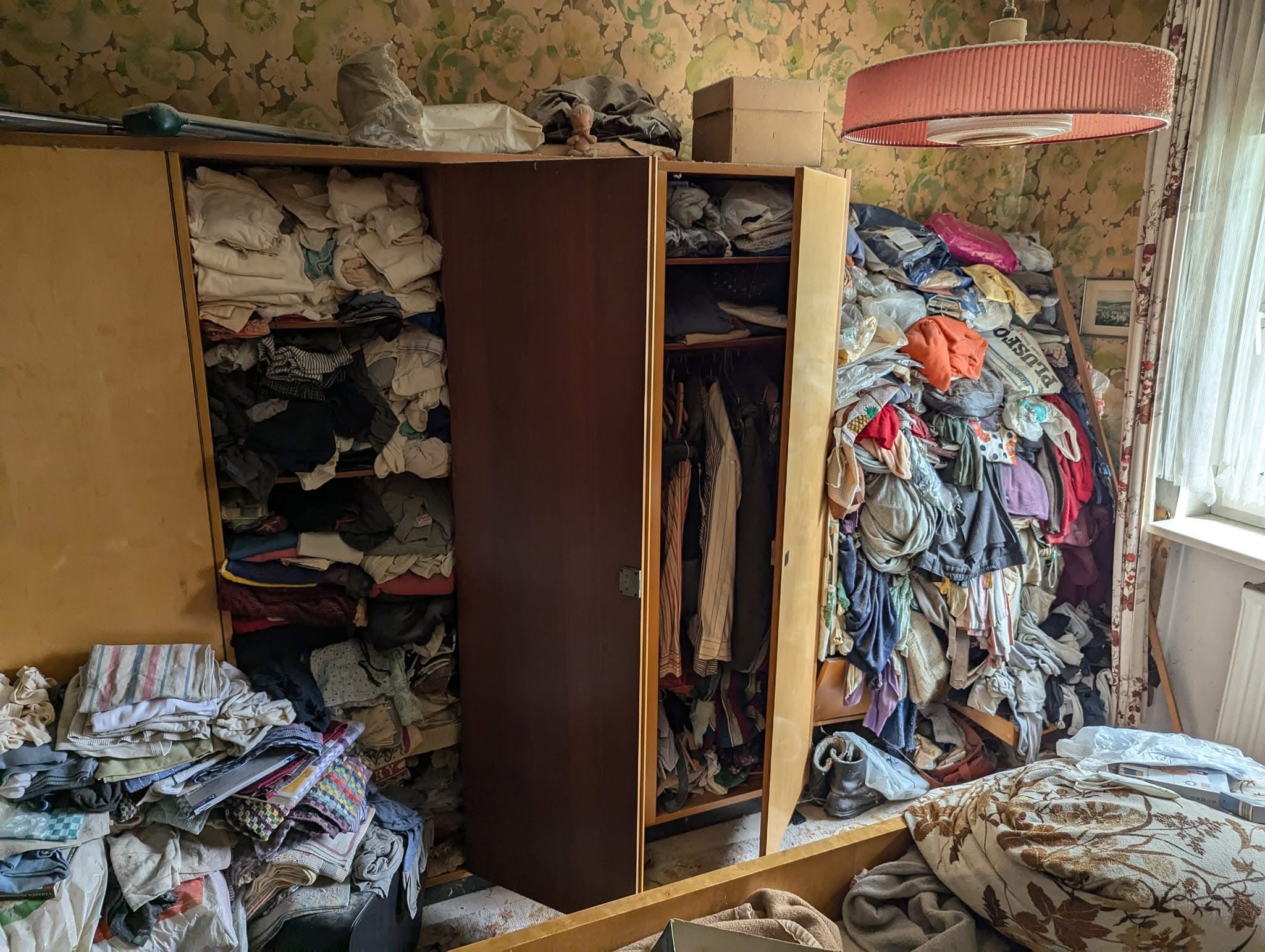 Room with packed wardrobes and accumulated household belongings