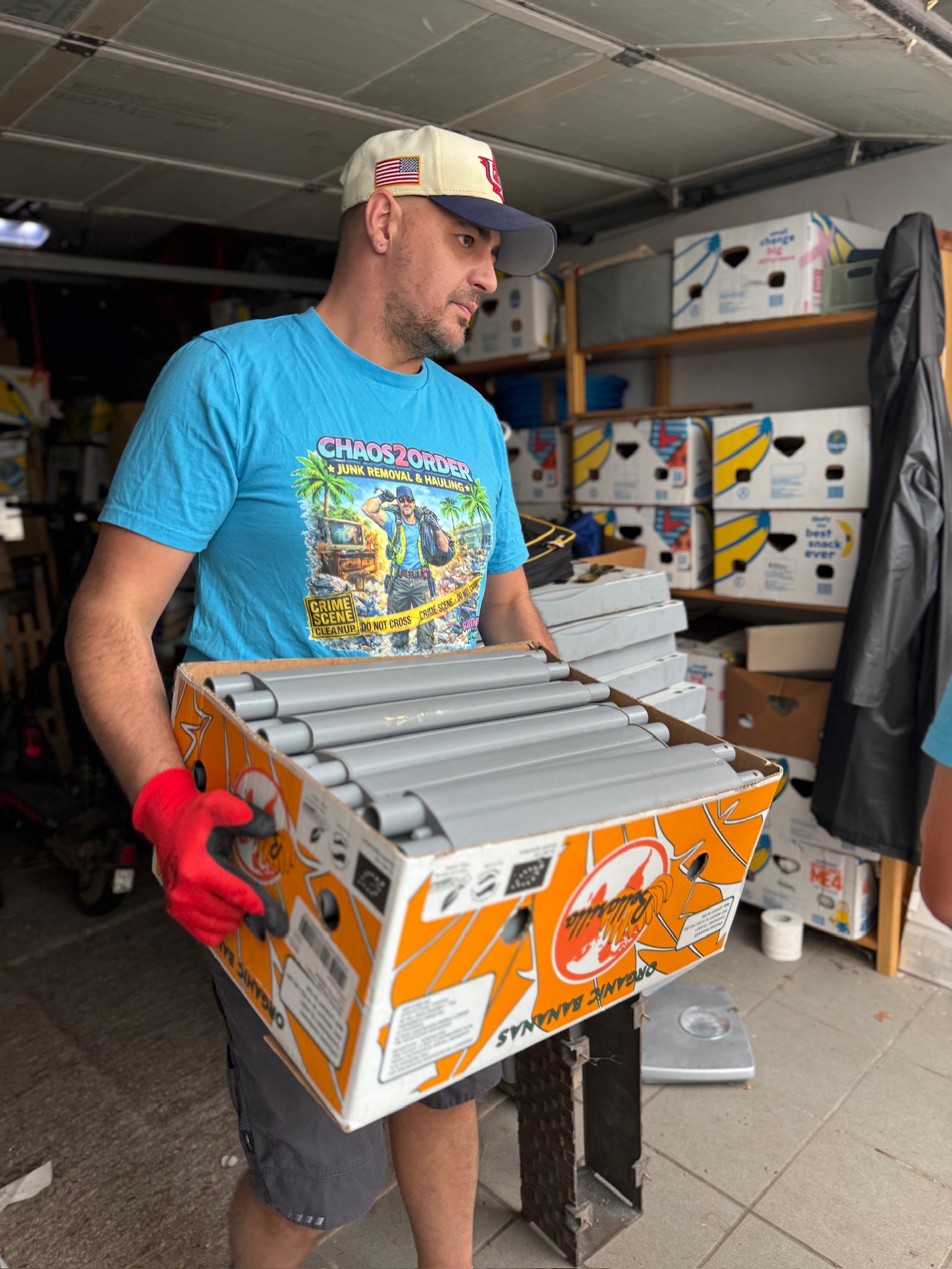 Crew member carrying boxed equipment during a garage cleanout