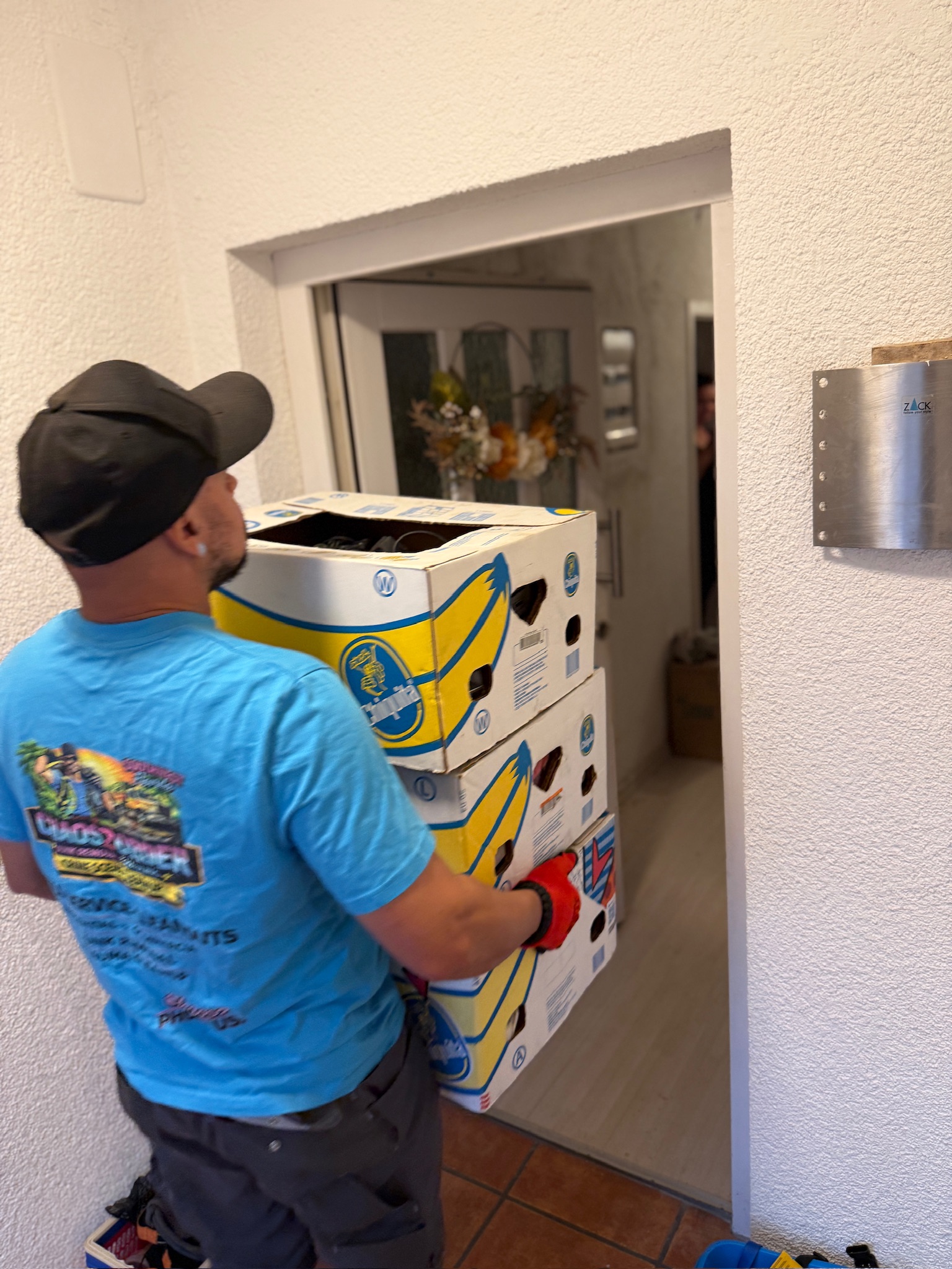 Chaos2Order crew member carrying boxes through a doorway