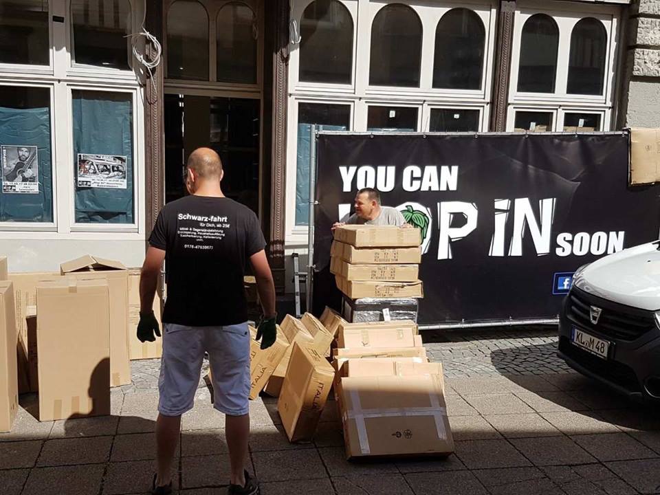 Worker moving boxes from a property beside a tram
