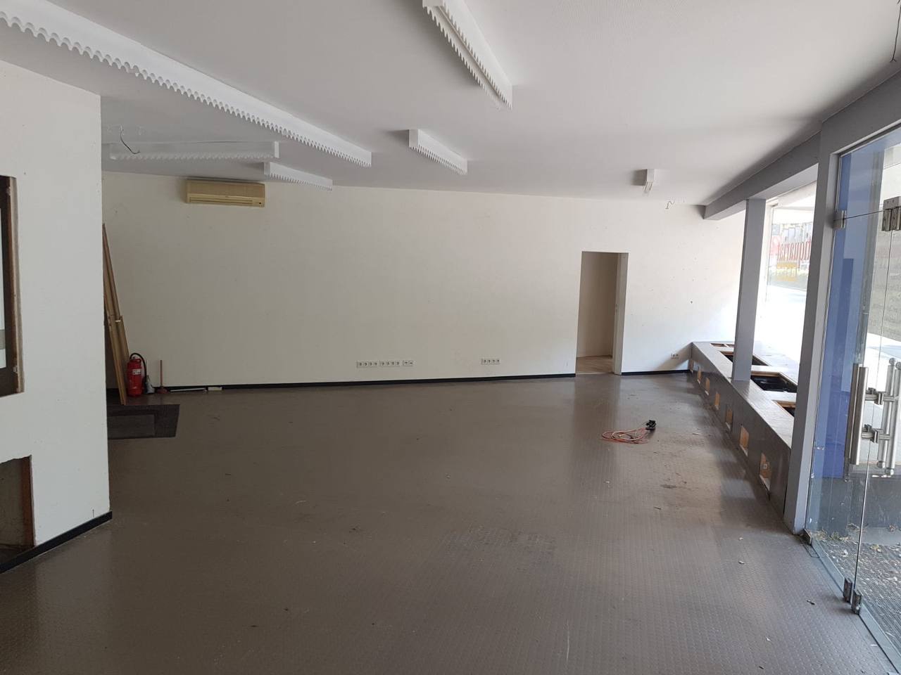 Cleared room with bare flooring and windows after a cleanout
