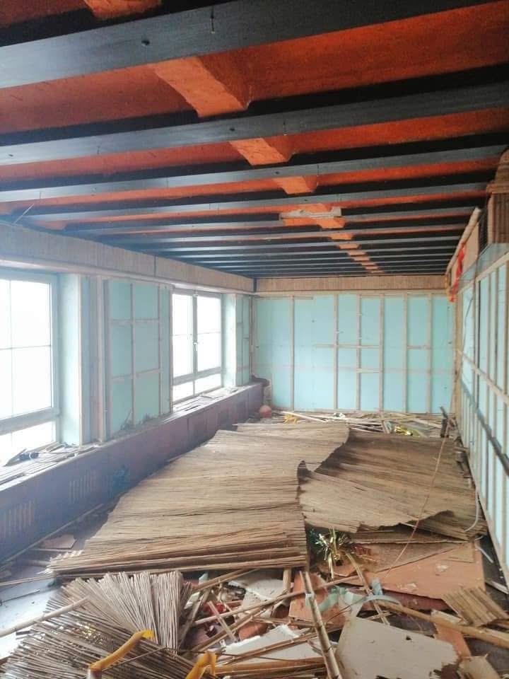 Long interior room with stacked material during a property cleanout